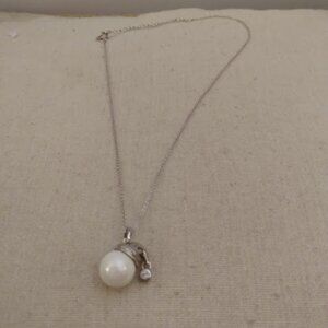 Faux pearl snowman head with hat and rhinestone trim.